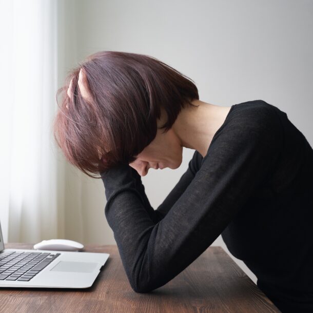 woman sitting at desk feeling overwhelmed