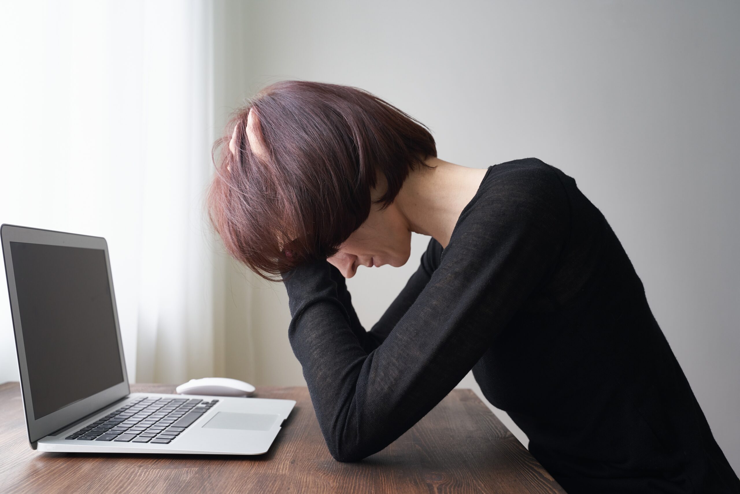 woman sitting at desk feeling overwhelmed